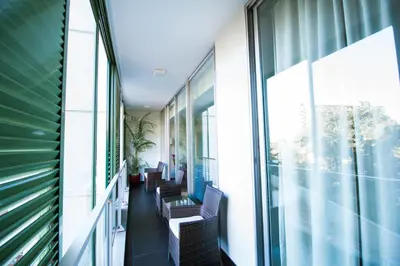 a corridor of a building with chairs and windows at Quinta da Nogueira in Funchal