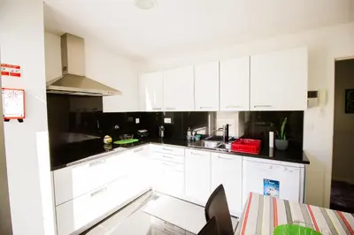 a white kitchen with white cabinets and a table at Quinta da Nogueira in Funchal
