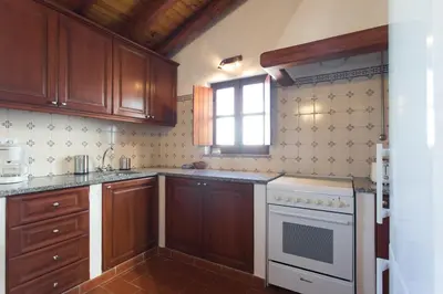 a kitchen with wooden cabinets and a white stove top oven at Casas da Capela do Monte, Country Houses in Lagos