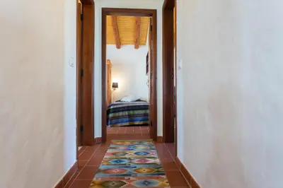 a hallway with a room with a bed and a rug at Casas da Capela do Monte, Country Houses in Lagos