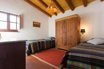 a bedroom with two beds and a wooden cabinet at Casas da Capela do Monte, Country Houses in Lagos