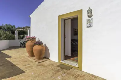 a white building with two large vases on a patio at Casas da Capela do Monte, Country Houses in Lagos