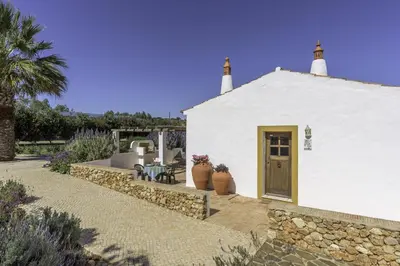 a white building with two vases in front of it at Casas da Capela do Monte, Country Houses in Lagos