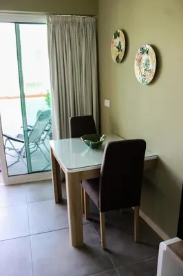 a dining room with a table and chairs and a balcony at Canavial Terrace@Heart of Funchal in Funchal