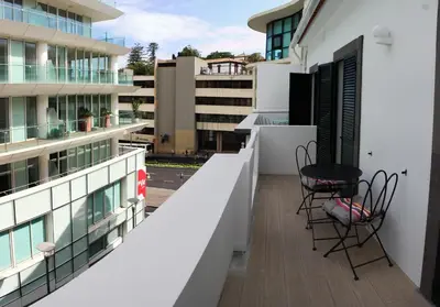 a balcony with two chairs and a table on a building at Canavial Terrace@Heart of Funchal in Funchal