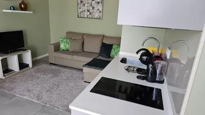 a small living room with a couch and a kitchen at Canavial Terrace@Heart of Funchal in Funchal