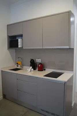 a kitchen with white cabinets and a counter top at Canavial Terrace@Heart of Funchal in Funchal