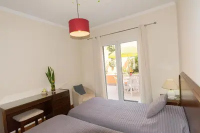 a bedroom with a bed and a desk and a window at Quinta da Torre in Câmara de Lobos