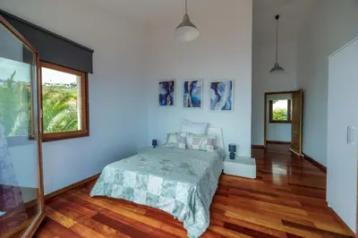 a bedroom with a bed and a large window at Casa Falésia in Caniço