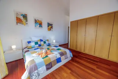 a bedroom with a bed and a wooden cabinet at Casa Falésia in Caniço