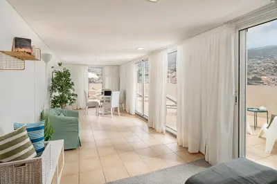 a living room with a view of a balcony at Jasmineiro I by An Island Apart in Funchal