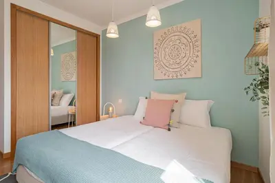a bedroom with a large white bed with a pink pillow at Jasmineiro I by An Island Apart in Funchal