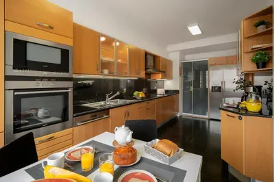 a kitchen with wooden cabinets and a table with food on it at Jasmineiro I by An Island Apart in Funchal