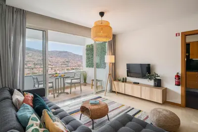 a living room with a couch and a tv at Jasmineiro I by An Island Apart in Funchal