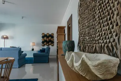 a living room with a couch and a chair at Vilas Mediterrâneo in Santa Cruz