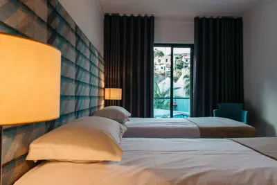 a bedroom with two beds and a window at Vilas Mediterrâneo in Santa Cruz