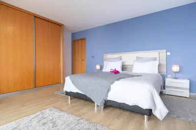 a bedroom with a white bed with a pink flower on it at Apartamento Goncalves in Arco da Calheta