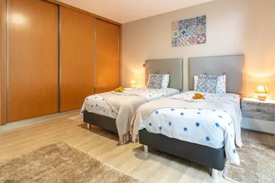 a bedroom with two beds and a closet at Apartamento Goncalves in Arco da Calheta