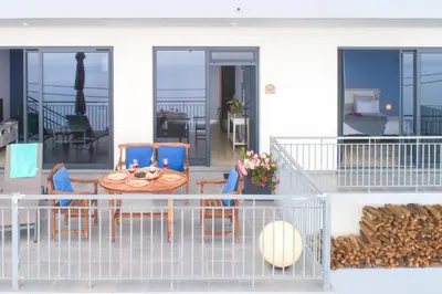 a patio with a table and chairs on a balcony at Apartamento Goncalves in Arco da Calheta