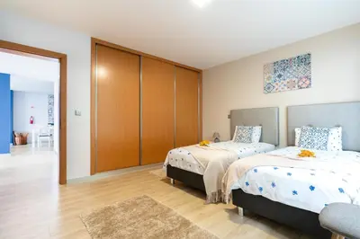 a bedroom with two beds and a closet at Apartamento Goncalves in Arco da Calheta