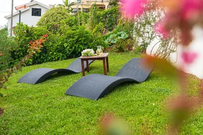 two chairs and a table in the grass at Apartamento Goncalves in Arco da Calheta