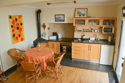 a kitchen with a table and chairs and a stove at Casa Horizonte in Arco da Calheta