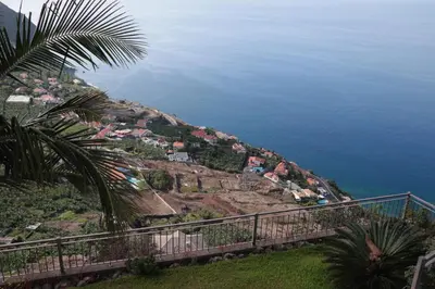 a view of a hill with houses and the ocean at Casa Horizonte in Arco da Calheta