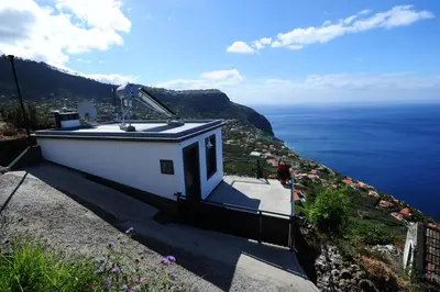 a small house with a view of the ocean at Casa Horizonte in Arco da Calheta