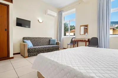 a bedroom with a bed and a couch and a table at Alojamento Local Trigal in Funchal
