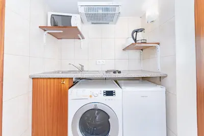 a laundry room with a washing machine and a sink at Alojamento Local Trigal in Funchal