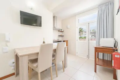 a living room with a table and chairs and a television at Alojamento Local Trigal in Funchal