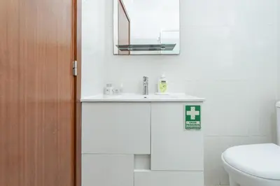a bathroom with a sink and a toilet and a mirror at Alojamento Local Trigal in Funchal