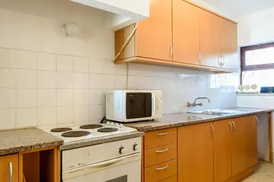 a kitchen with a stove and a microwave at Casa Sol e Praia in Luz
