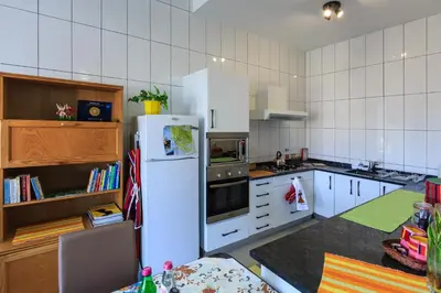 a kitchen with a white refrigerator and white cabinets at Vila Morning Sun in Calheta