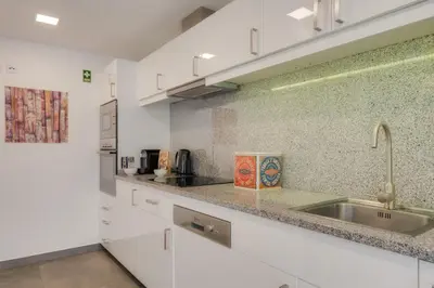 a kitchen with white cabinets and a sink at Casa da Praça Apartments - by Casas na Ilha in Funchal