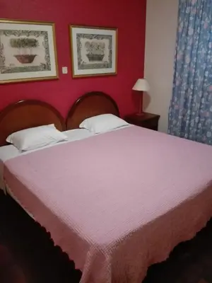 a bedroom with a large bed with a red wall at Estalagem Corte do Norte in Ponta Delgada