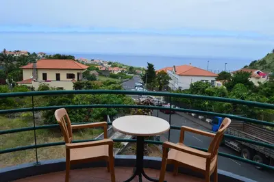 a balcony with a table and chairs and a view at Estalagem Corte do Norte in Ponta Delgada