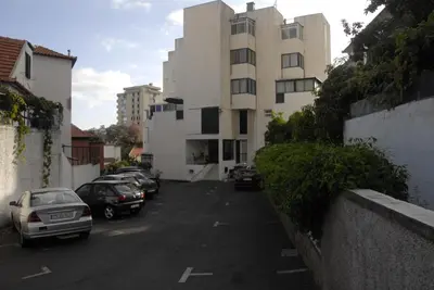 a parking lot with cars parked in front of a building at Olivia's Place in Funchal