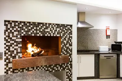 a fireplace in a kitchen with a fire in it at Ocean Cliff in Ponta do Sol