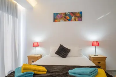 a bedroom with a bed with two nightstands and two lamps at Ocean Cliff in Ponta do Sol