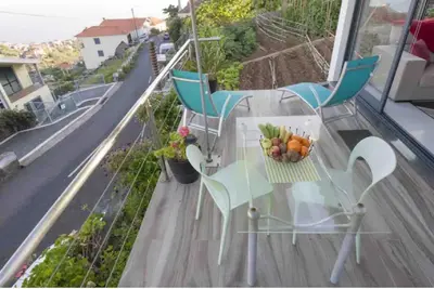 a glass table with a bowl of fruit on a balcony at Crystal House in Calheta