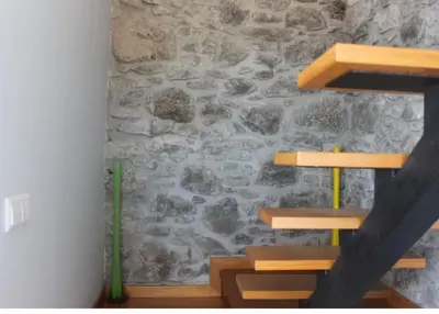 a room with wooden shelves and a stone wall at Crystal House in Calheta