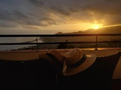 a person sitting on a balcony watching the sunset at Murteiras Living in Funchal