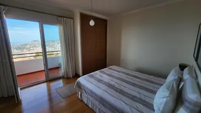a bedroom with a bed and a large window at Murteiras Living in Funchal