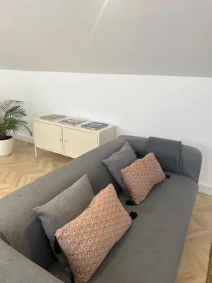 a gray couch with pillows in a living room at Rooftop Apartment city center in Funchal