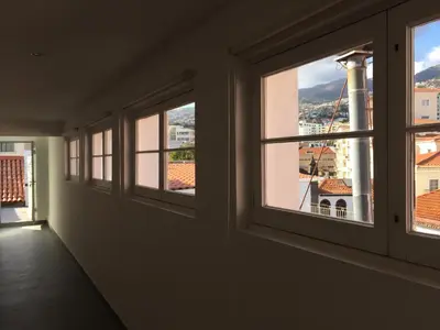 a room with windows with a view of a city at Rooftop Apartment city center in Funchal