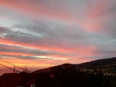 a sunset over a hill with a cloudy sky at Casa Mao-Cheia in Arco da Calheta