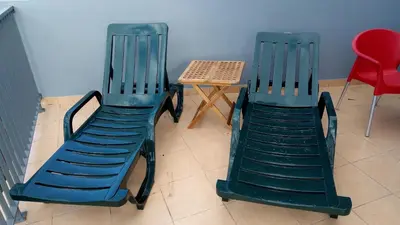 two green chairs sitting next to a table and a table at Casa Mao-Cheia in Arco da Calheta