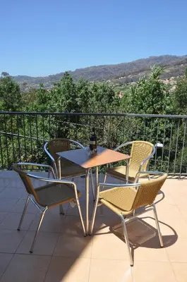 a table and chairs on a balcony with a view at Casa Mao-Cheia in Arco da Calheta