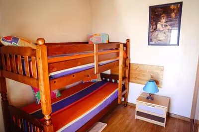 a childs bedroom with a bunk bed and a lamp at Raposeira Chloe T2 in Fajã da Ovelha